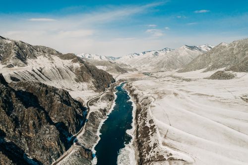 Free A stunning aerial shot of snow-covered mountains and a winding river in Russia, showcasing winter landscapes. Stock Photo