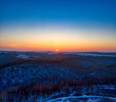 A picturesque aerial view of a winter sunrise over a snowy landscape in Plainview, MN.