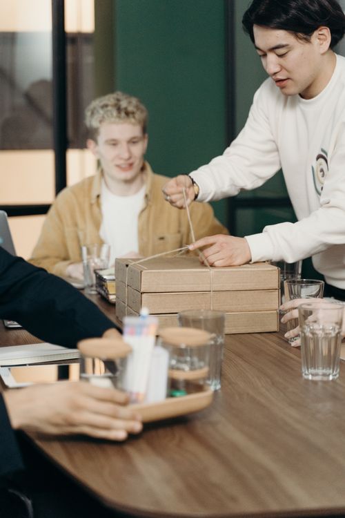 Free A diverse group of colleagues share a casual lunch during a break at the office. Stock Photo