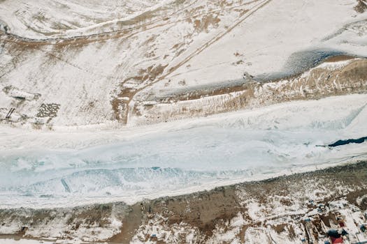A stunning aerial shot of a snowy, frozen river landscape in Ongudaysky District, Altay, Russia.