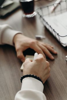 Hands writing on a notepad during a business meeting, capturing ideas and planning in a modern office setting.