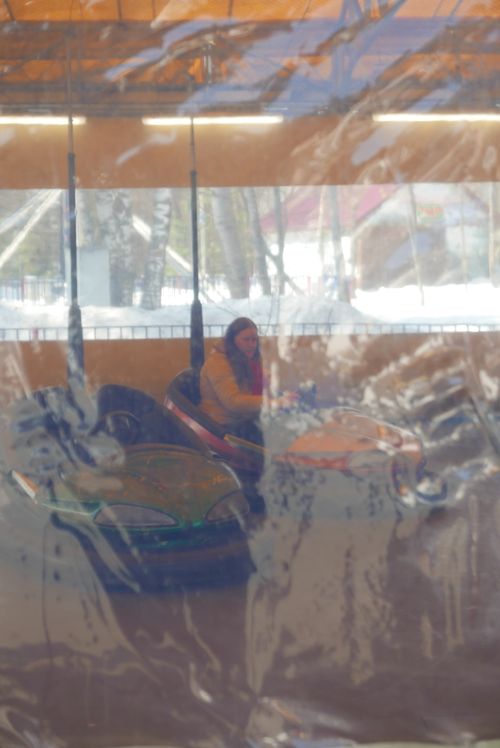 Free A woman rides bumper cars in an indoor amusement park setting, offering a fun and vibrant experience. Stock Photo
