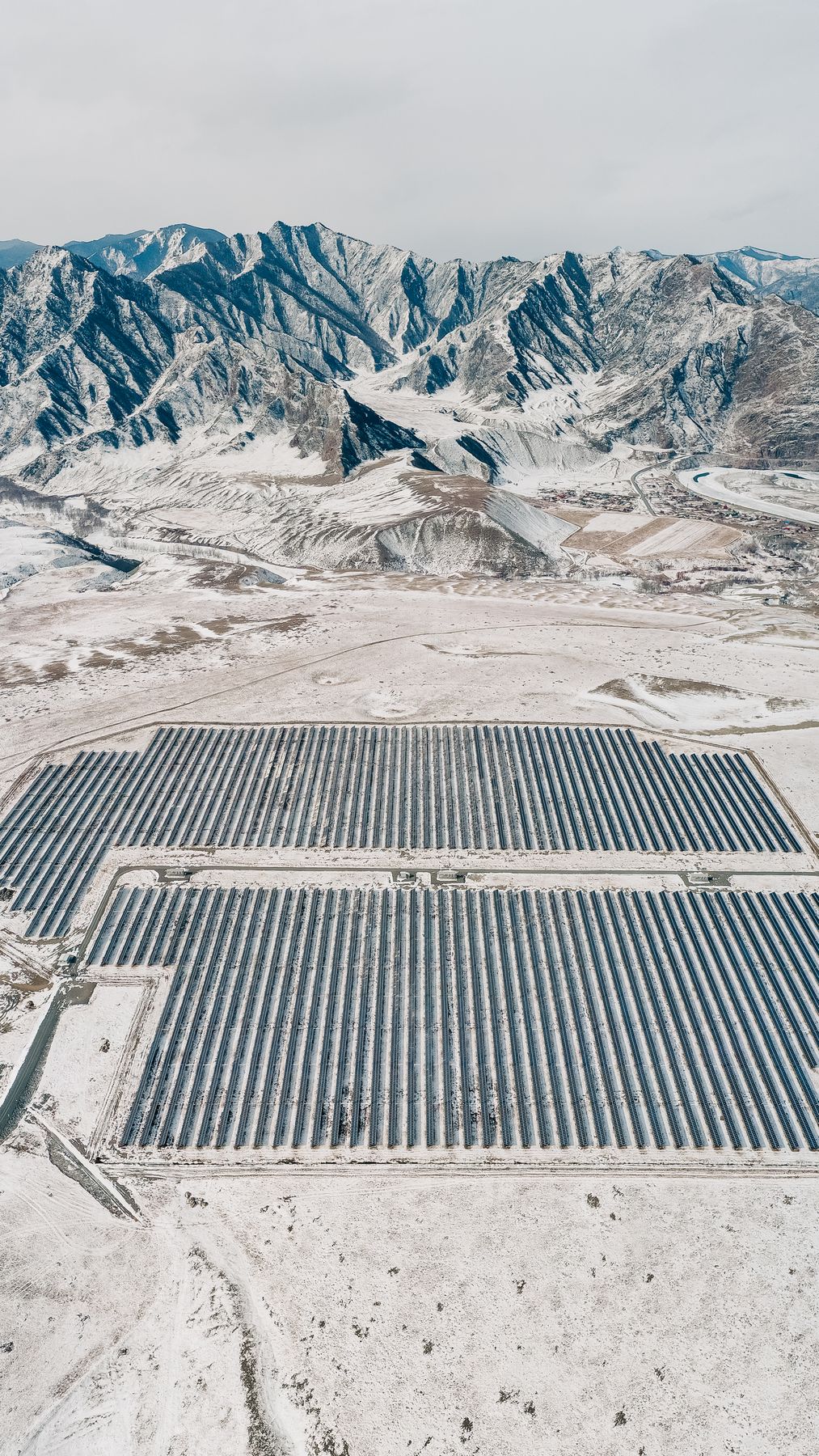 Panoramic view of a solar panel field at dawn, with the inland Spanish sierras in the background