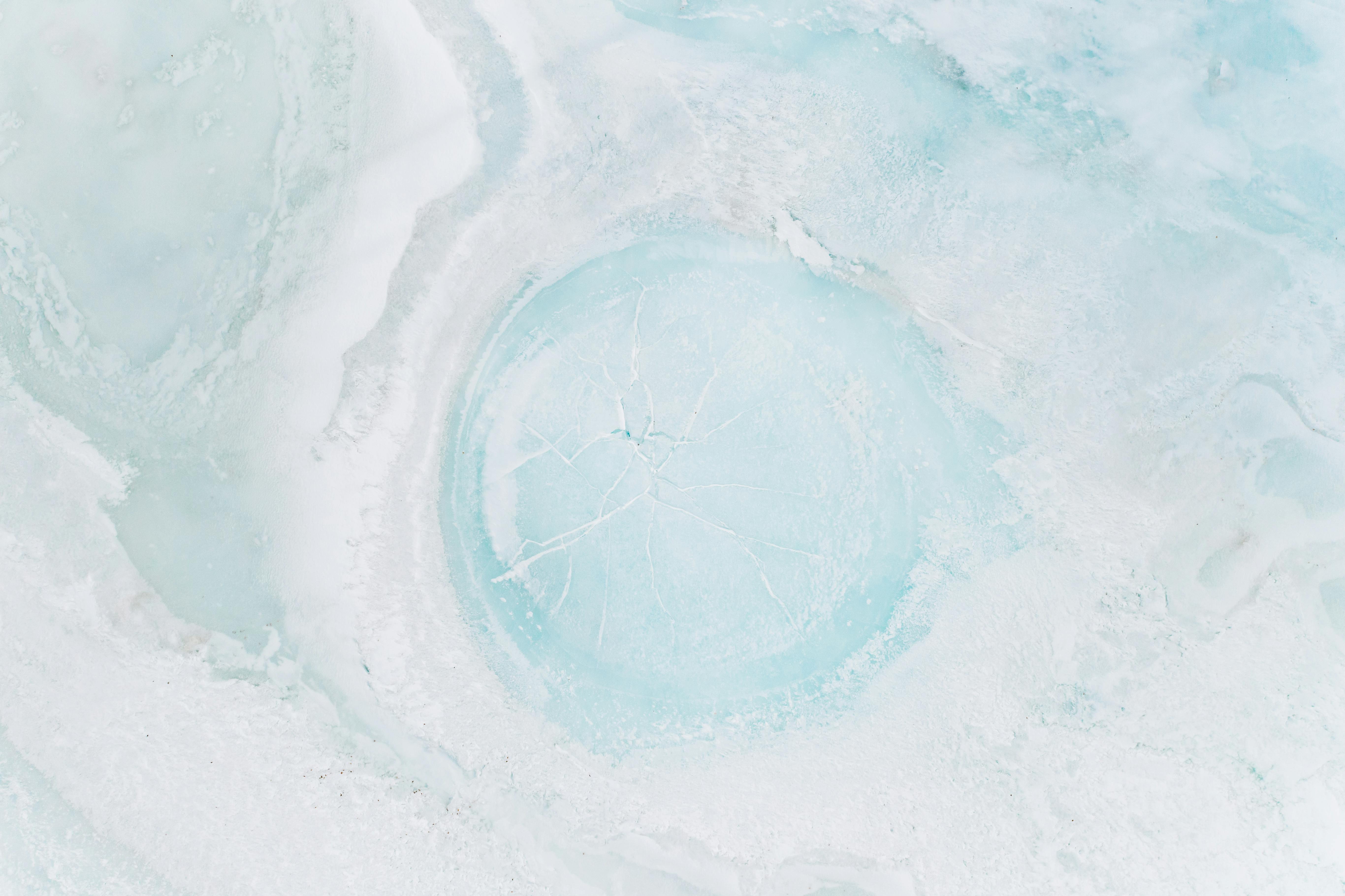 A striking aerial shot of a cracked frozen ice surface, highlighting natural patterns and textures.