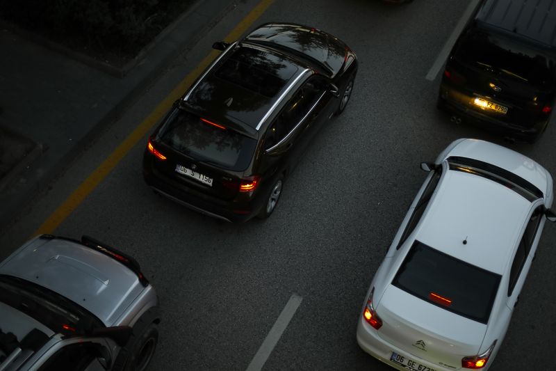 Aerial shot showing multiple cars driving on a city road during the evening, illustrating urban traffic.