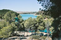 西班牙宁静的蓝色山湖被郁郁葱葱的绿色植物环绕，景色令人惊叹