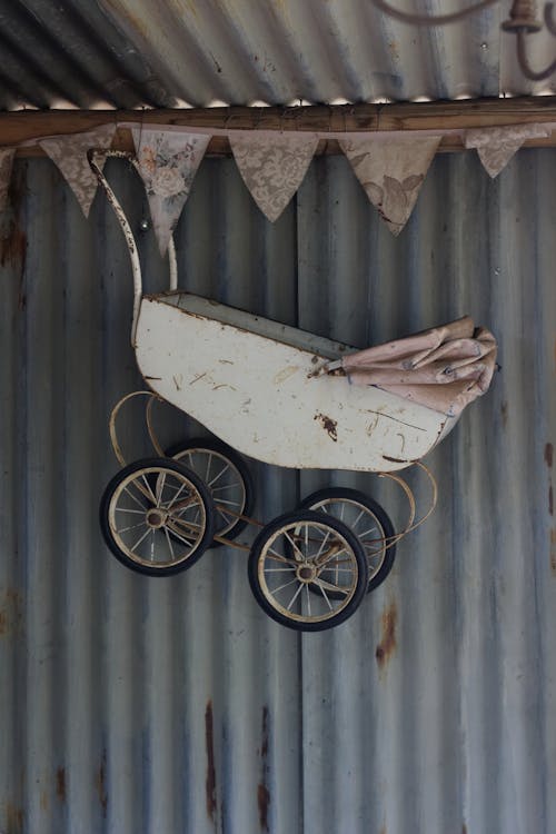 White Steel Baby Carriage Hanging From the Ceiling