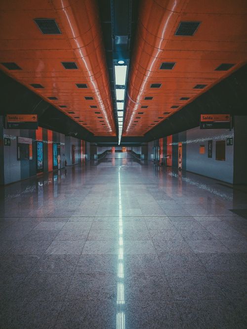 Free Perspective view of empty underground passage with modern geometric architecture and glowing illumination in urban subway station Stock Photo