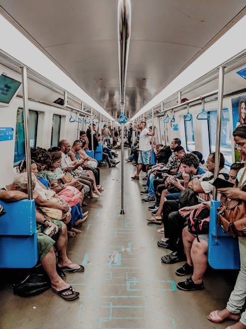 Photo by Willian Santos Passengers seated and standing inside a crowded subway train during a typical commute.