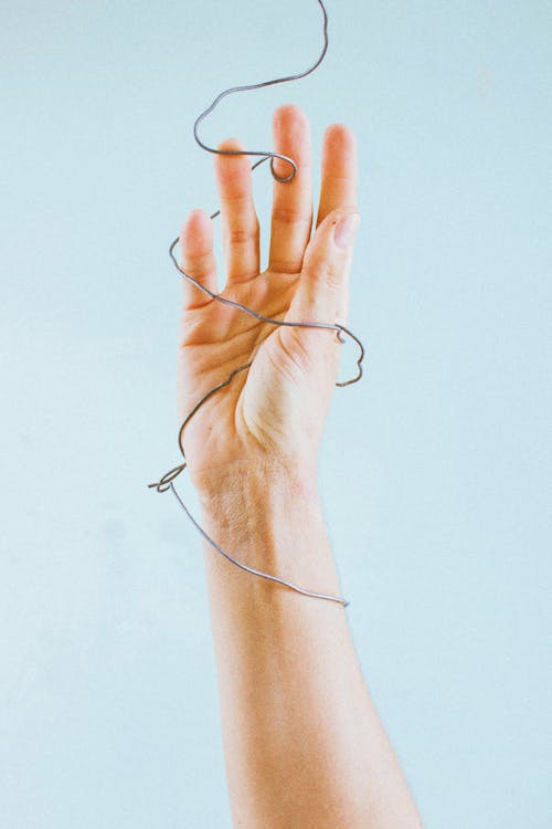A Person Holding a Coiled Wire · Free Stock Photo
