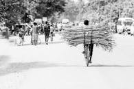 在坦桑尼亚凯拉的一条繁忙街道上，一个人正骑着自行车运送木柴