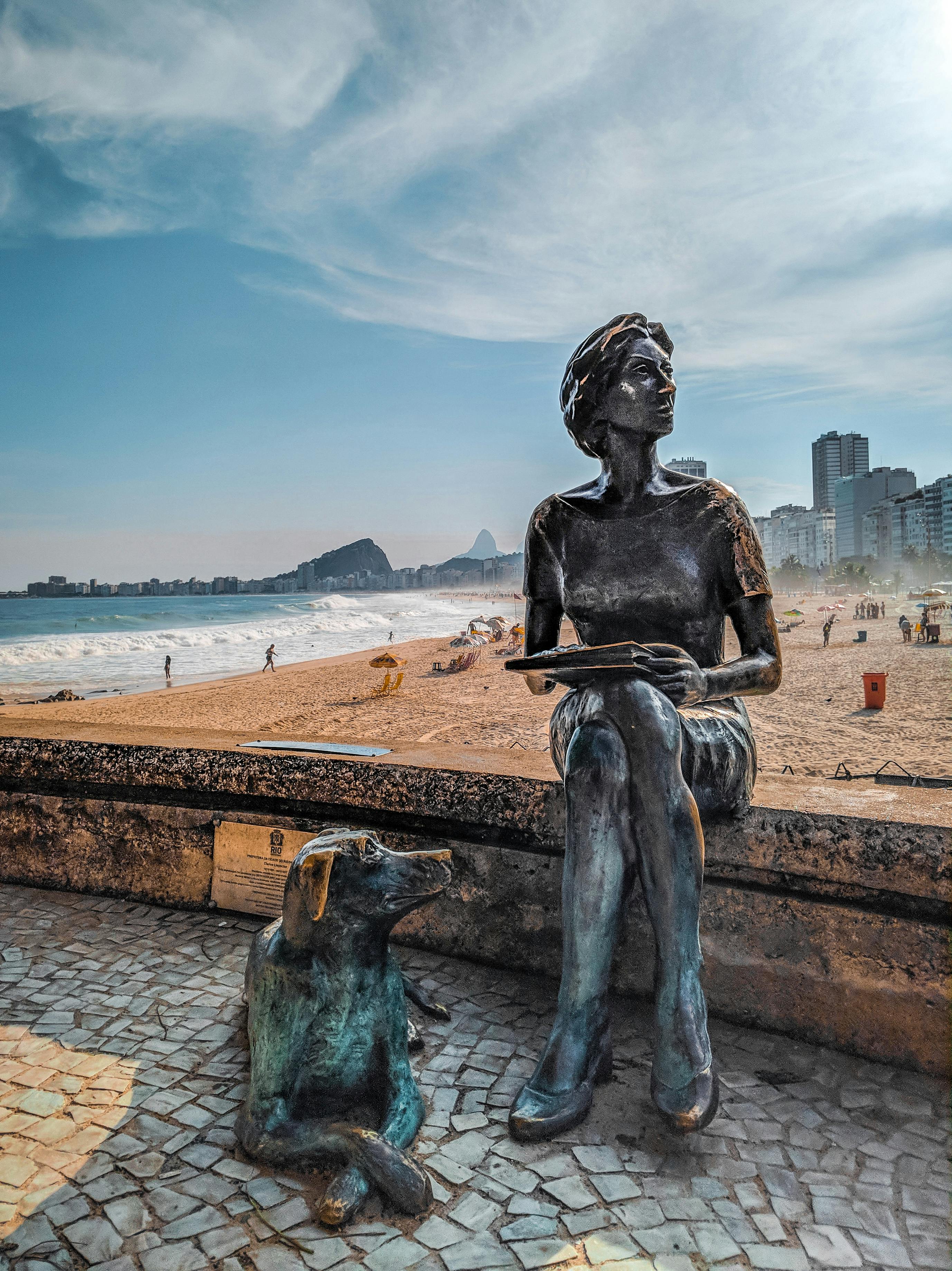 Sculptural composition with figure of loyal dog resting near female writer with book located on Copacabana beach in Rio de Janeiro in Brazil