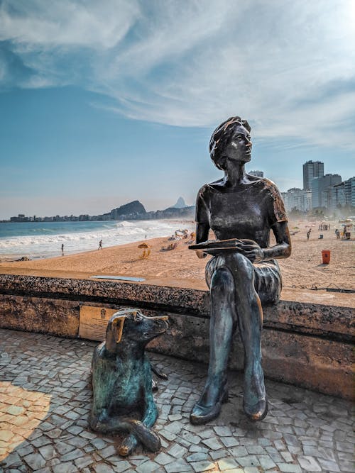 Free Sculptural composition with figure of loyal dog resting near female writer with book located on Copacabana beach in Rio de Janeiro in Brazil Stock Photo