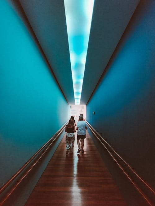 People walking in illuminated hallway