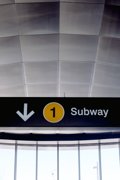 Low angle of arrow down sign on entrance of modern subway station in daylight