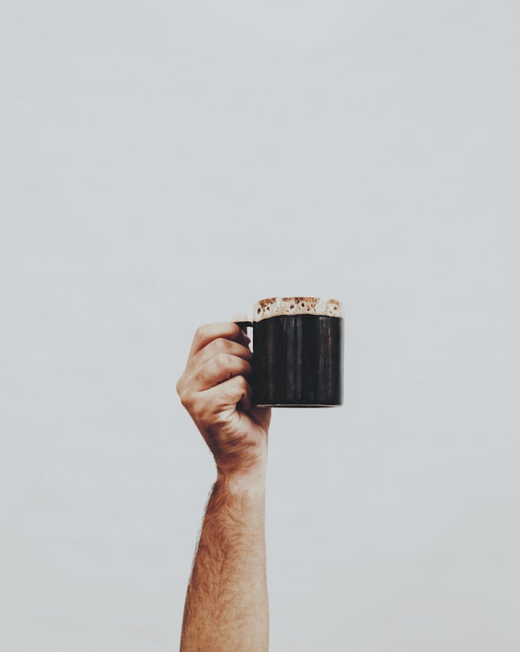 Crop Man With Mug Of Coffee On Light Background