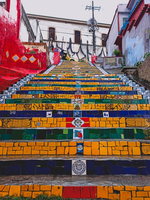 Free Bright staircase with illustrations on rough steps between old house walls in city in daytime Stock Photo