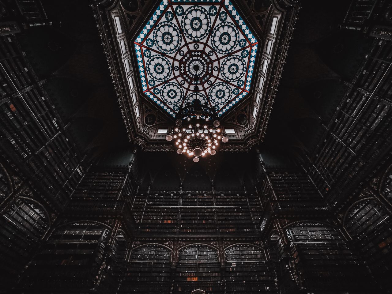 from below of old library interior with lamp on decorative ceiling and
