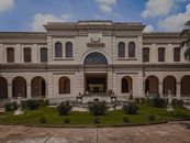 Old museum facade against sculptures on lawn in city