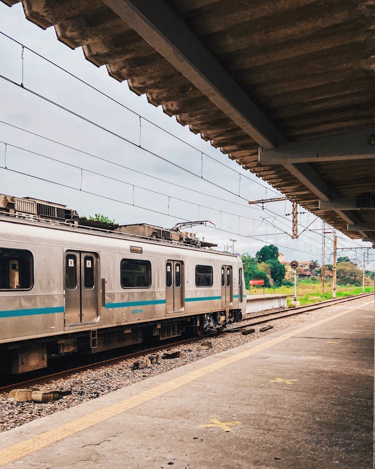 Old Electric Train On Railroad Against Empty Platform