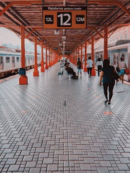 Passengers walk along a lively train station platform, showcasing daily urban commute life.