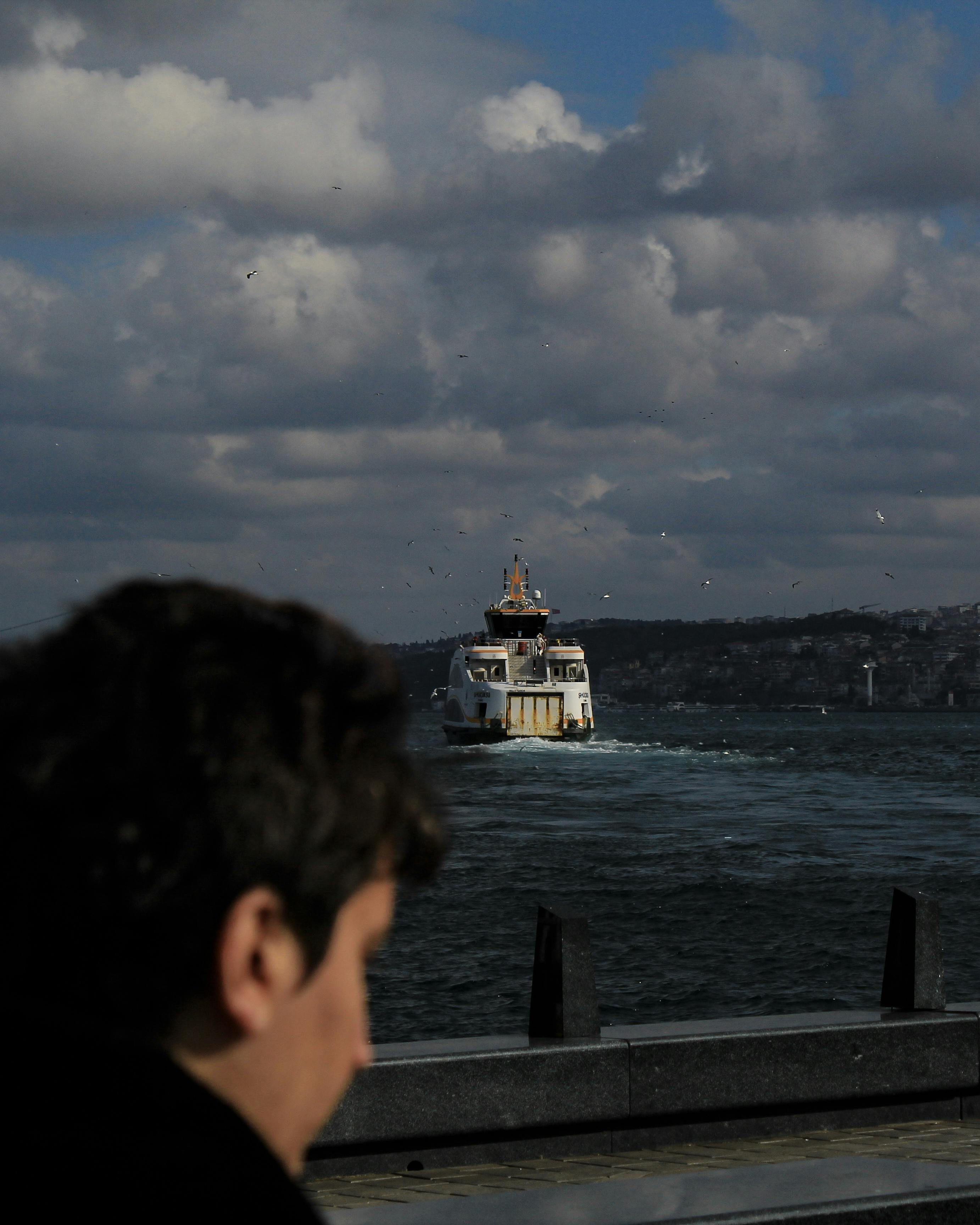 Free Ferry traveling on the Bosporus with a cloudy sky backdrop. Atmospheric shot. Stock Photo