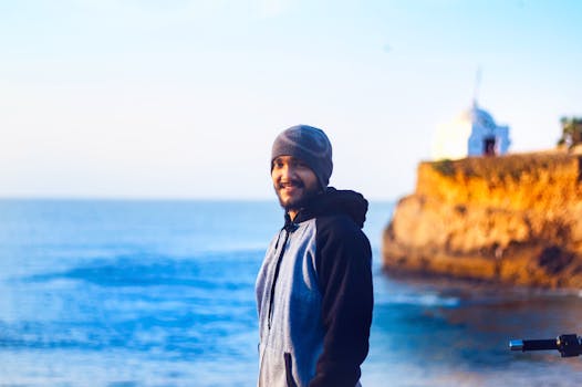 Portrait of a young man in front of the ocean at Diu lighthouse during sunrise.