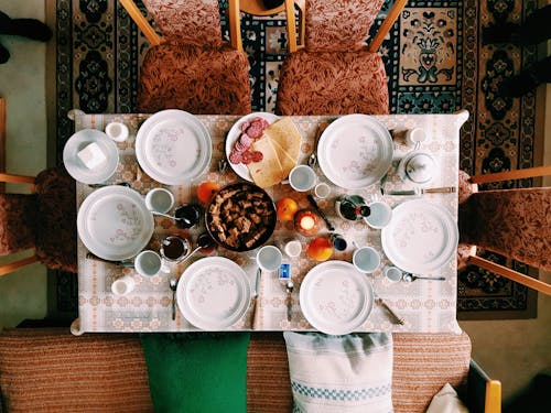 Fotografia De ângulo Elevado De Um Jantar Posicionado Na Mesa E Rodeado Por Cadeiras Acolchoadas