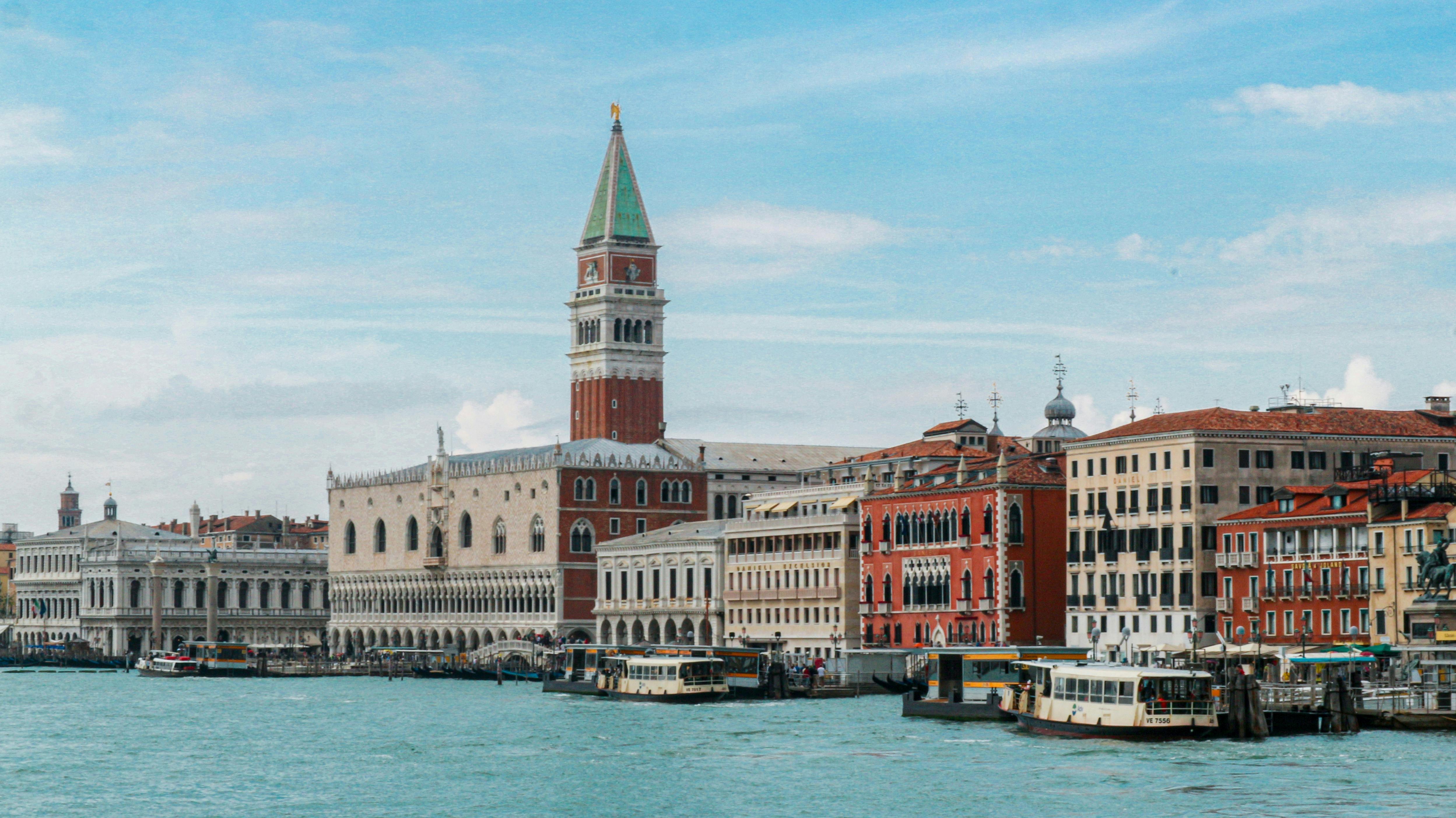 Free Iconic Venice waterfront with St Mark's Campanile under a clear blue sky. Stock Photo