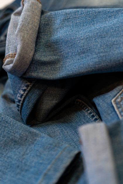 Blue jeans with folded hems laid flat — photo by Enric Cruz López on Pexels