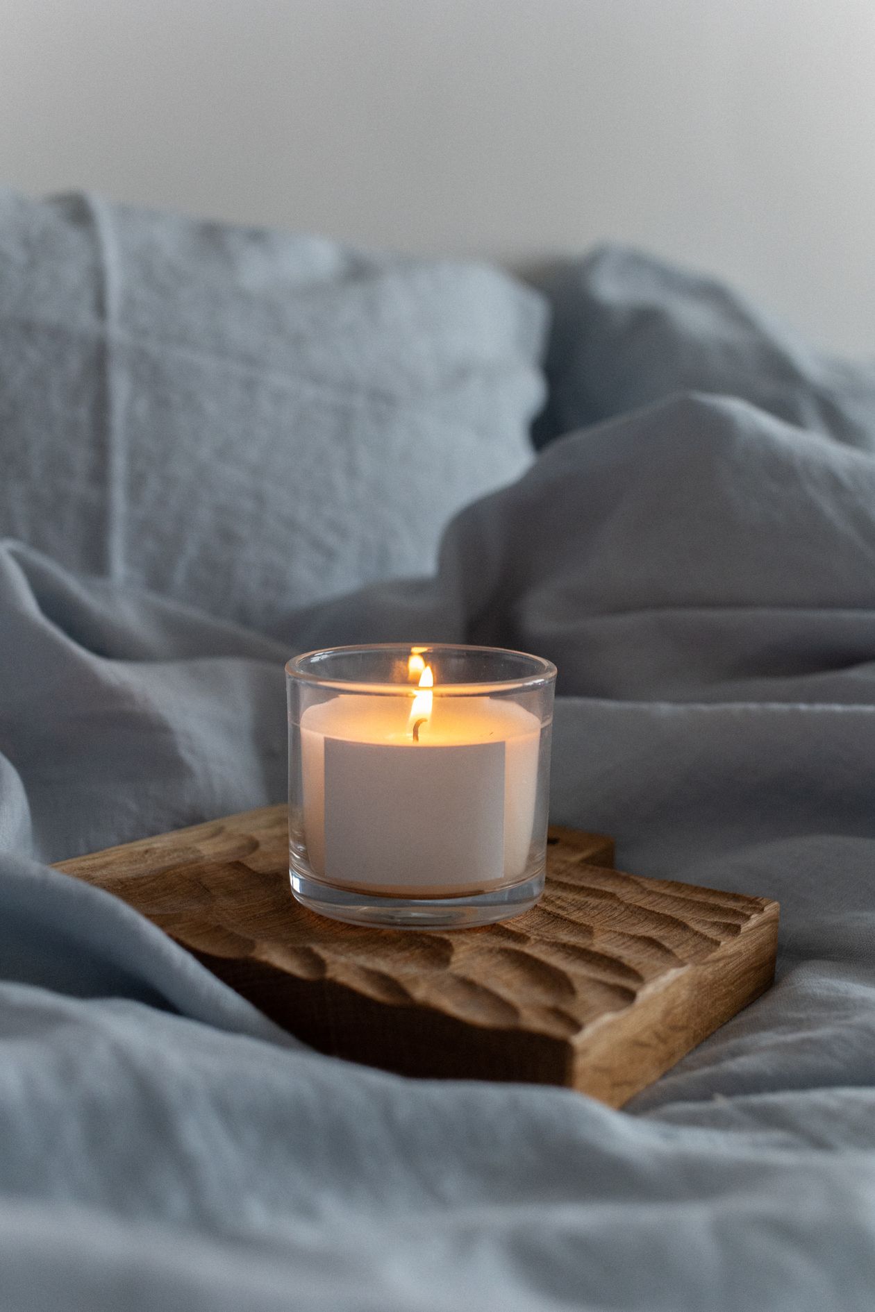 Wooden tray on a nightstand in a cozy small bedroom.