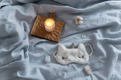 Free Lighted Candle on the Bed Stock Photo