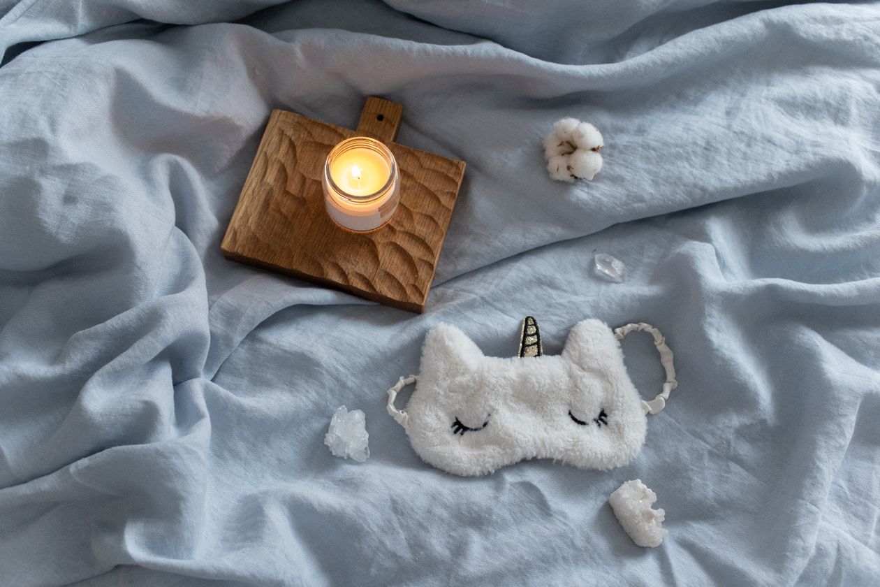 Bedroom with lit candle and soft textiles for warm ambient light