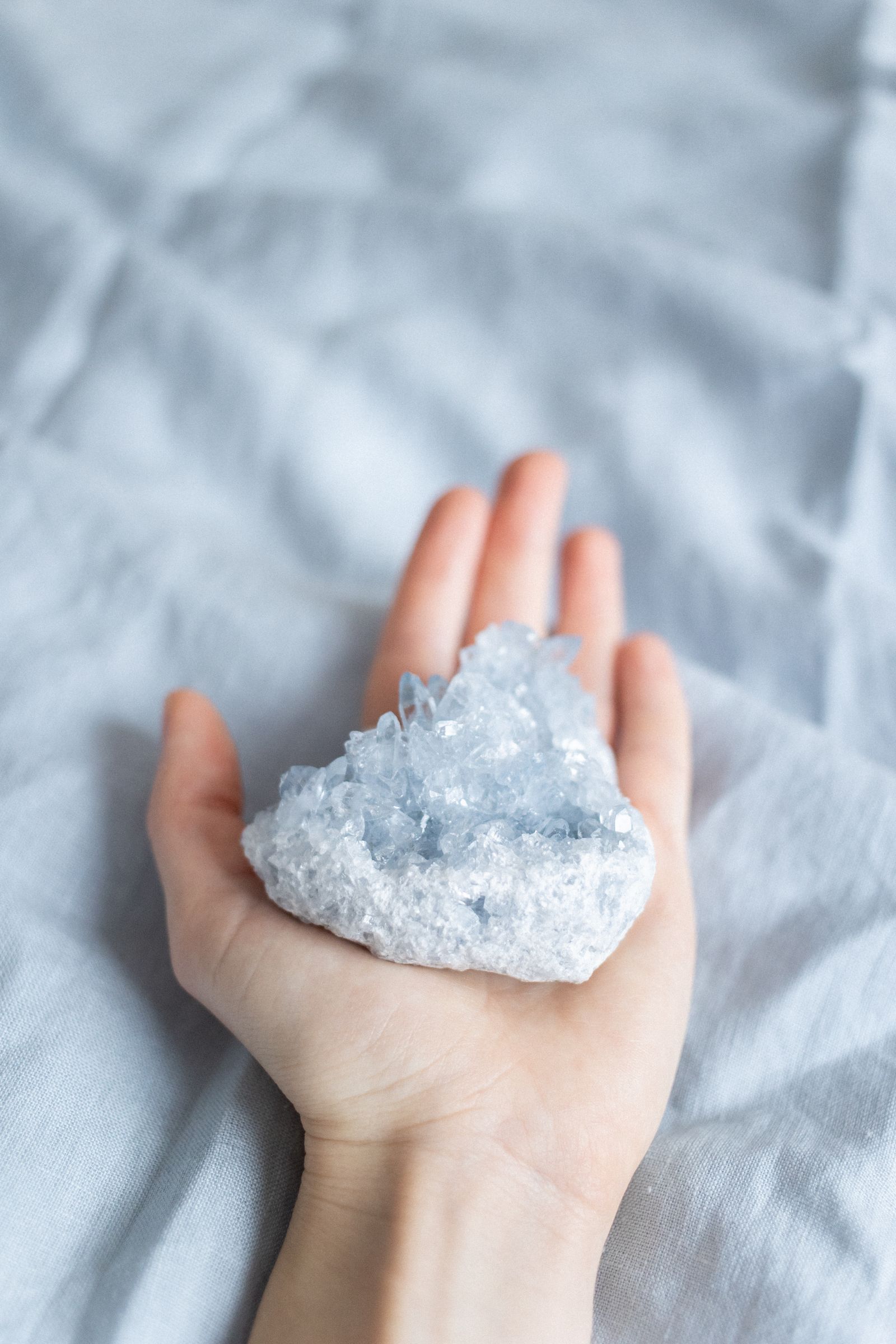 Close-up of hands holding polished blue crystal stones