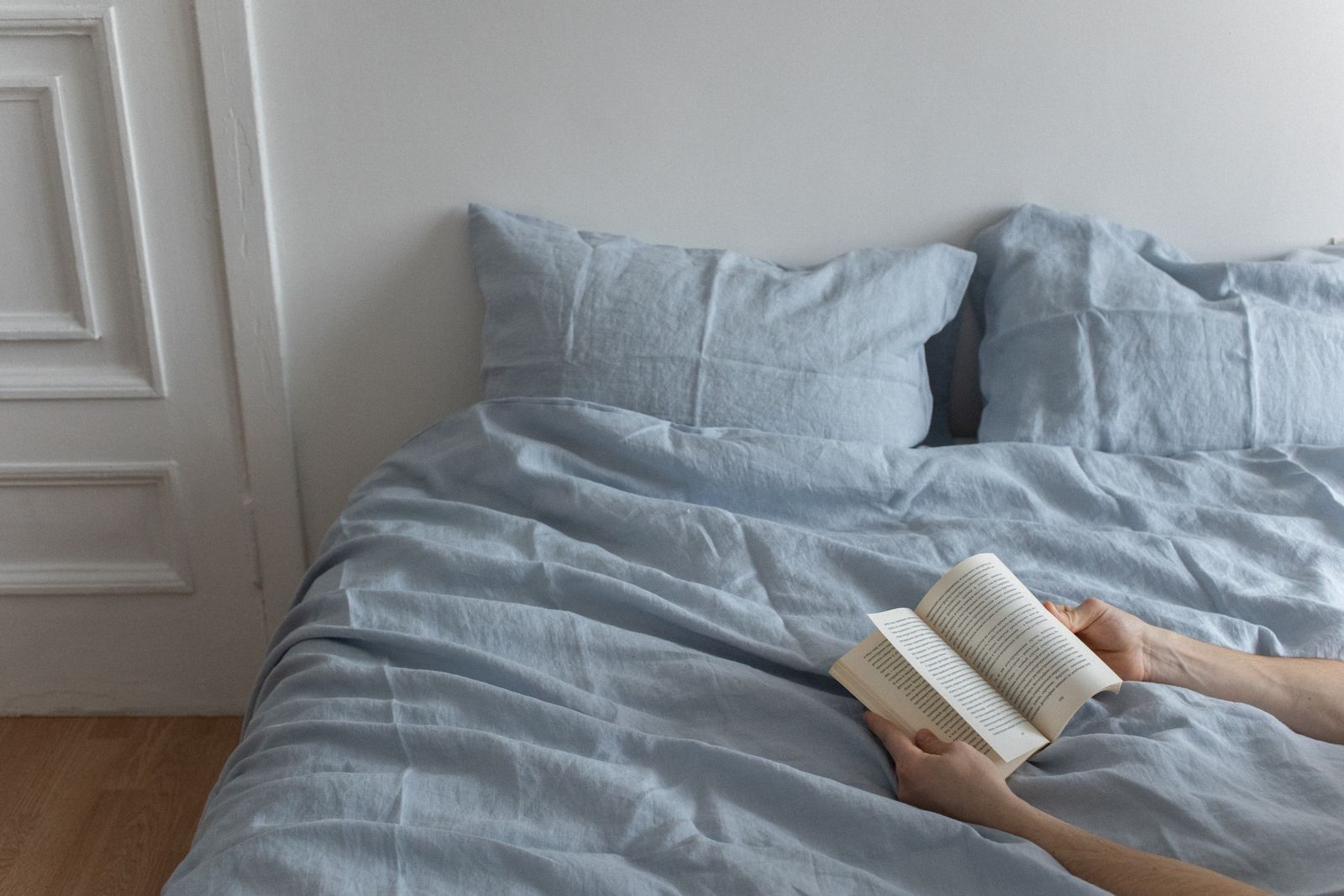 Relaxed bedroom setting with linen bedding and a quiet reading moment
