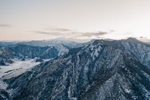 Stunning aerial view of the snow-covered Altai Mountains under a crisp clear sky.