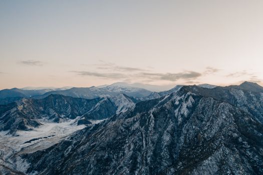 Explore the stunning snow-covered peaks of the Altai Mountains in this captivating aerial shot.