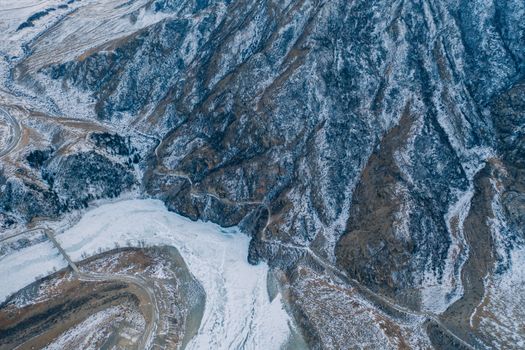 Drone shot capturing the snow-covered landscape of the Altai Mountains in winter.