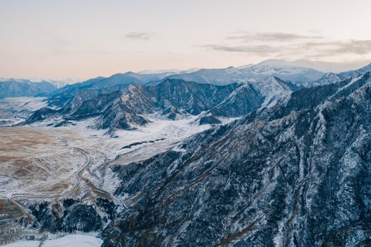 A stunning aerial view of snow-covered Altai Mountains in winter, showcasing nature's beauty.