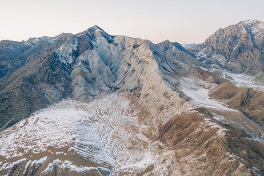 Aerial view of the snow-dusted Altay mountains during twilight, showcasing natural beauty in Russia.
