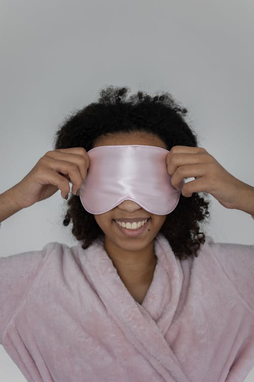 Free Close-Up Shot of an Afro-Haired Woman in a Bathrobe Wearing a Sleep Mask Stock Photo