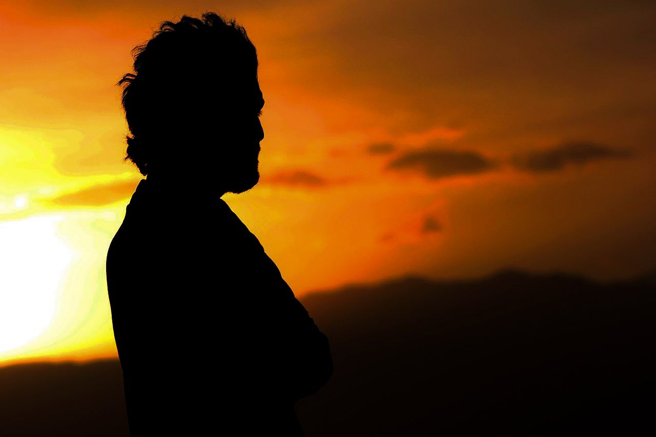 silhouette of a man standing against a vibrant sunset in kabul afghani