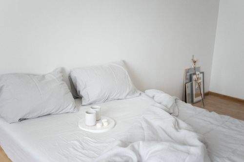 Free Serene minimalist bedroom featuring white bedding and simple decor for a tranquil ambiance. Stock Photo