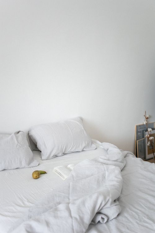 Free Minimalist bedroom with white bedding, pillows, and cozy ambiance. Stock Photo