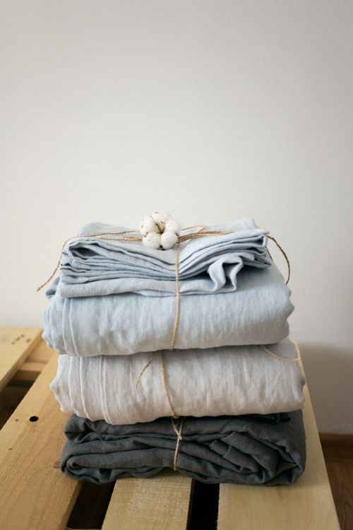 Free Neatly folded linen blankets tied with cotton on wooden crate, minimal style. Stock Photo