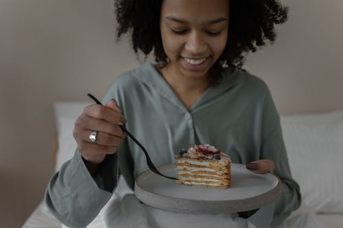 Free Woman in Pajamas Eating Breakfast in Bed Stock Photo