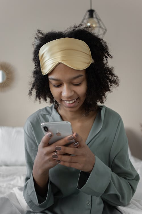 Free Woman in Pajamas Using Smartphone Stock Photo