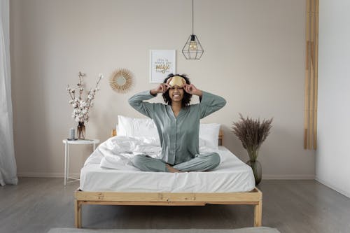 Free Woman in Pajamas Sitting on Bed Stock Photo