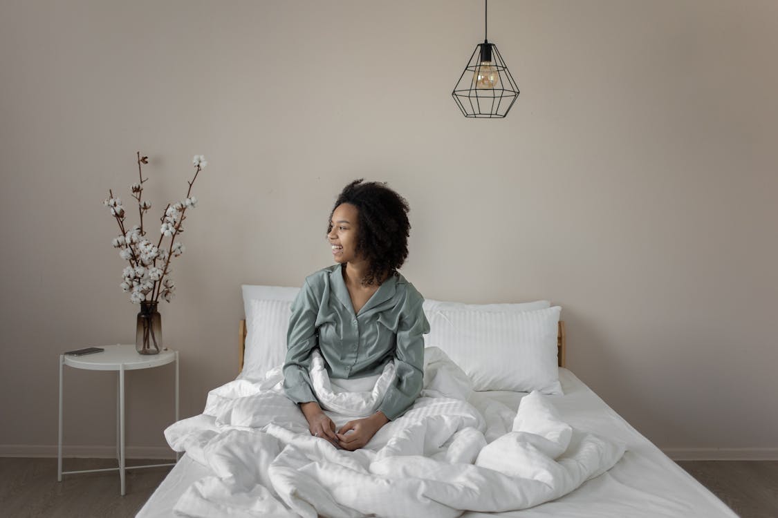 Free A Woman Sitting on the Bed Stock Photo