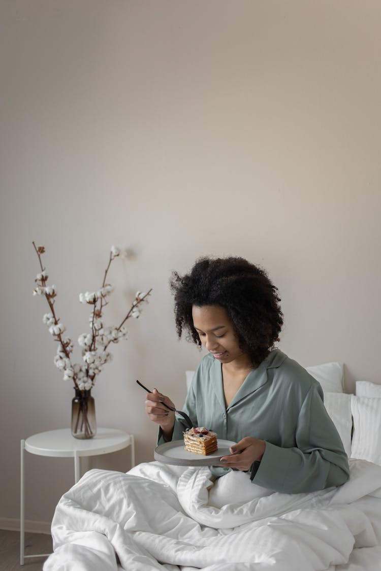 Woman In Pajamas Eating Breakfast In Bed